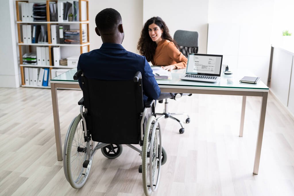 Two Young Businesspeople Working On Laptop At Workplace