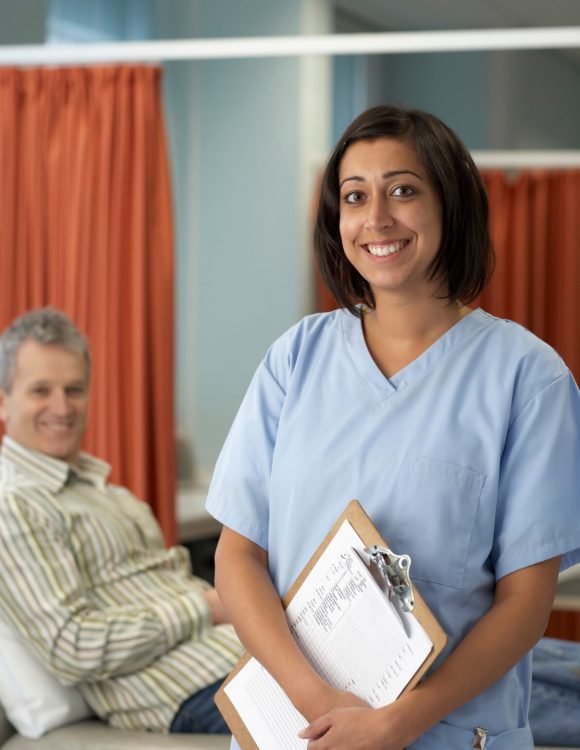 Smiling nurse, patient behind